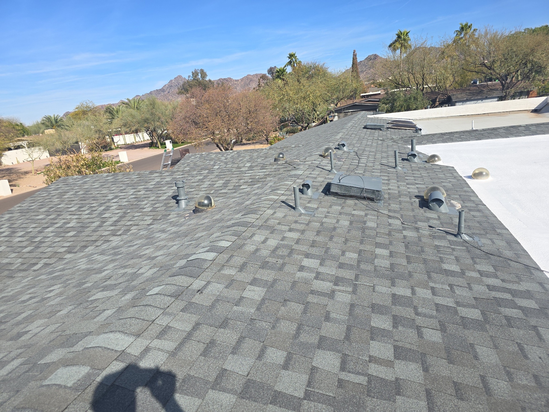 Designer shingle re-roof · Paradise Valley · 85253 — Aging shingle field on a luxury Paradise Valley home with multiple penetrations, vents, and a tie-in to an existing flat roof.