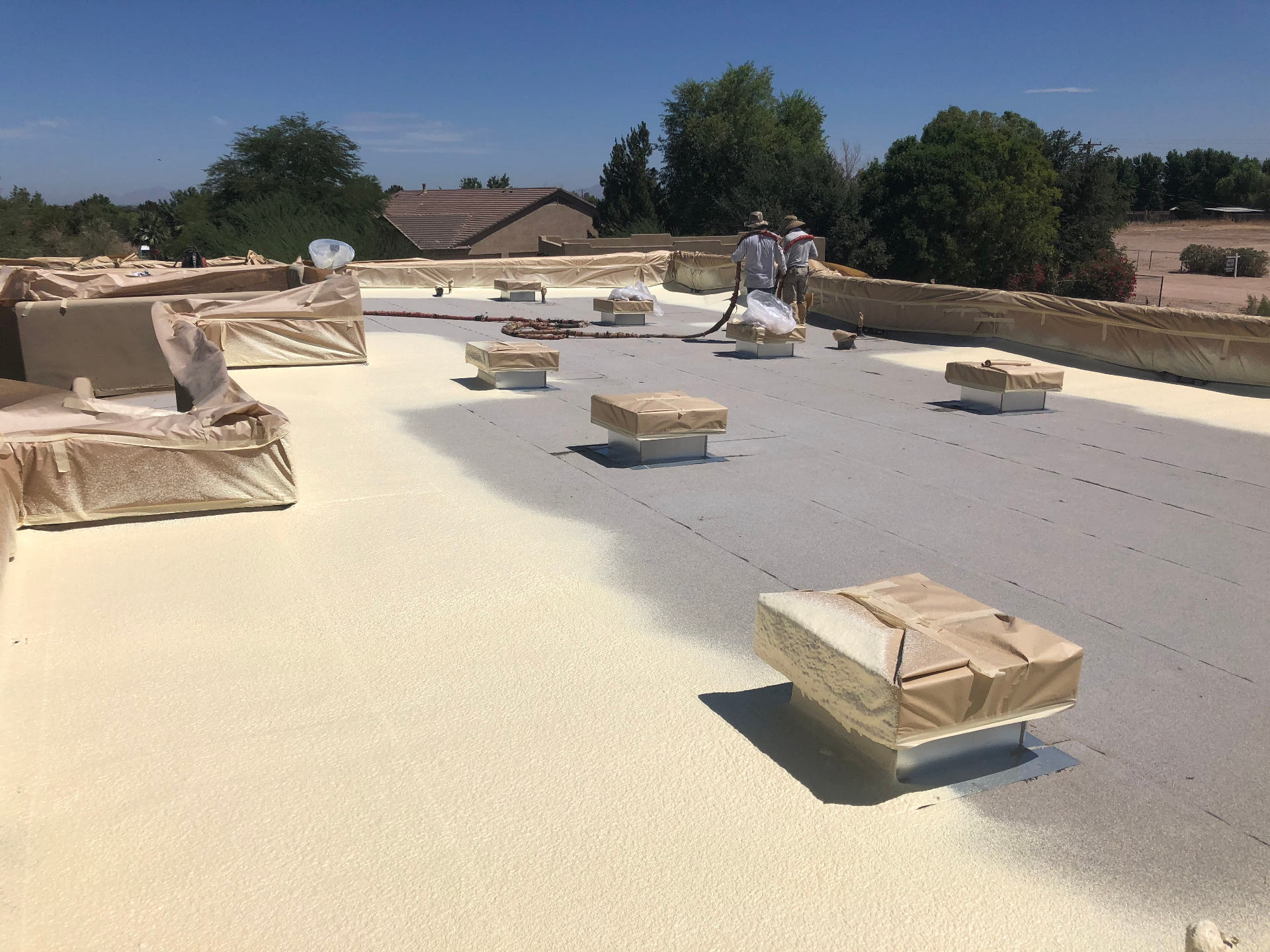 Foam recoat — final coat · Phoenix Valley — Foam roof due for its 5–10 year recoat before the UV barrier broke down and exposed the foam itself.
