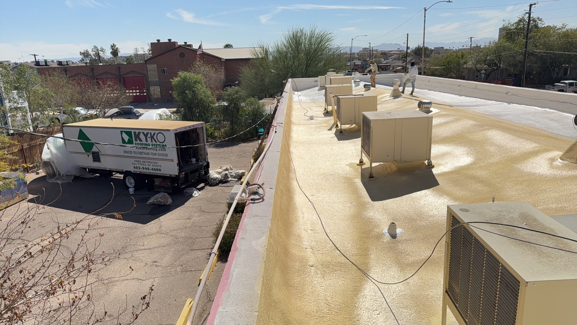 Commercial foam recoat · Central City, Phoenix 85007 — Aging foam coating worn through to the foam in spots — UV breakdown starting along the parapet and around RTUs.