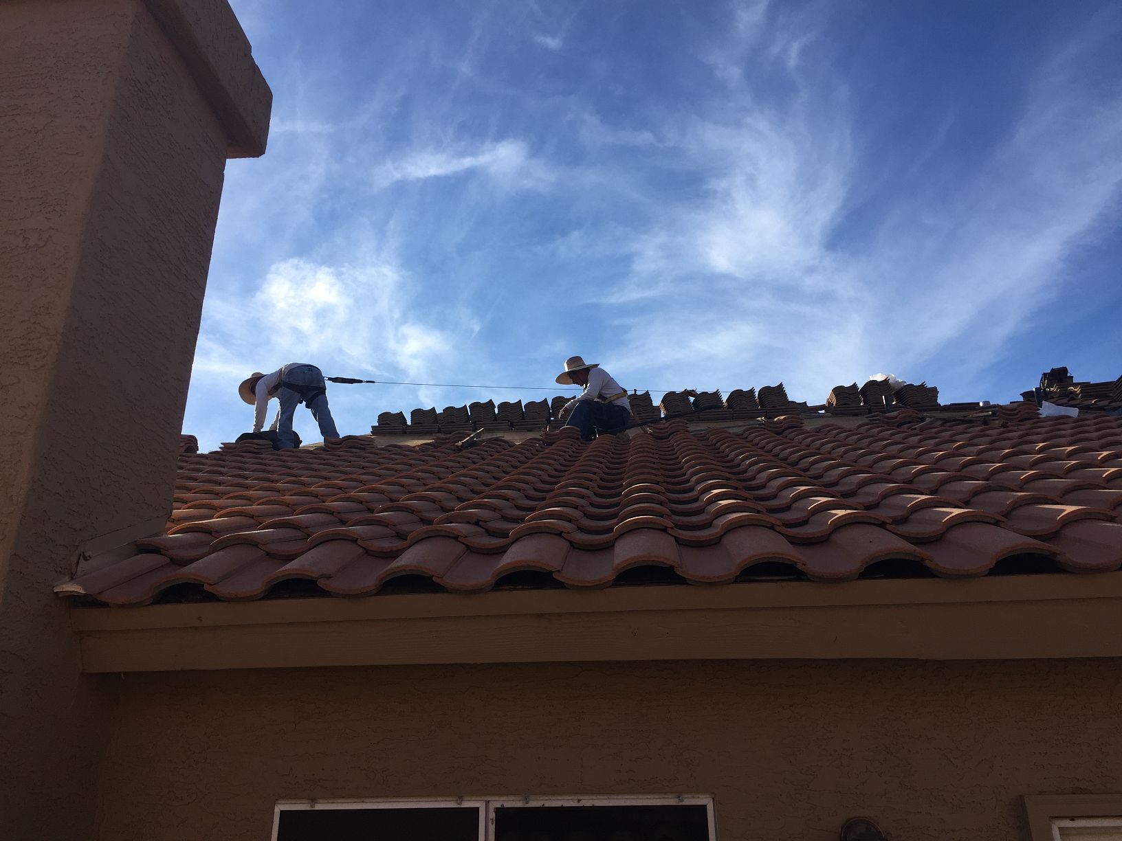 Clay S-tile · Scottsdale · January 2026 — Lifted ridge tiles and broken hip course after a microburst — water staining at two interior walls.